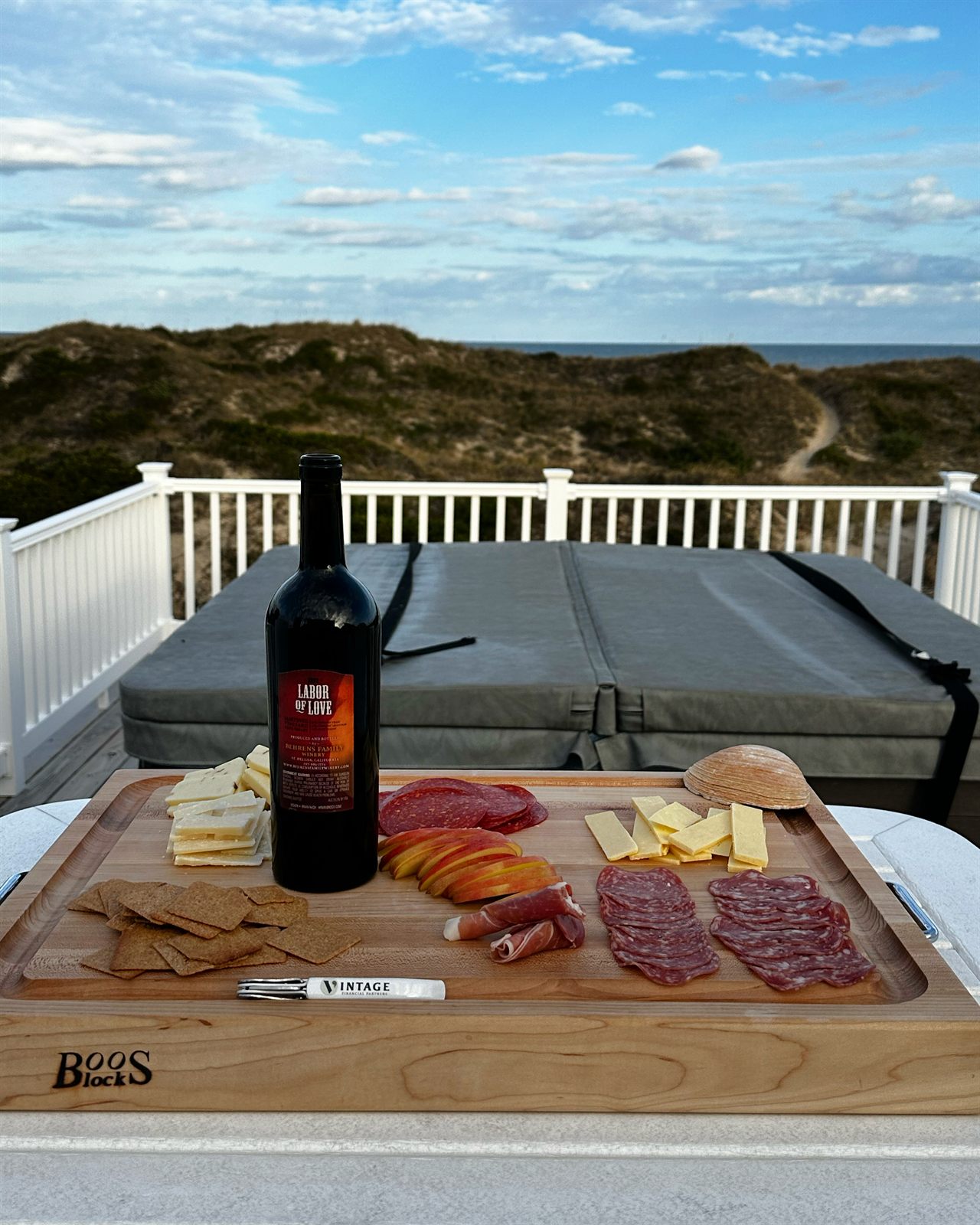 Charcuterie board and wine on the deck beside the hot tub