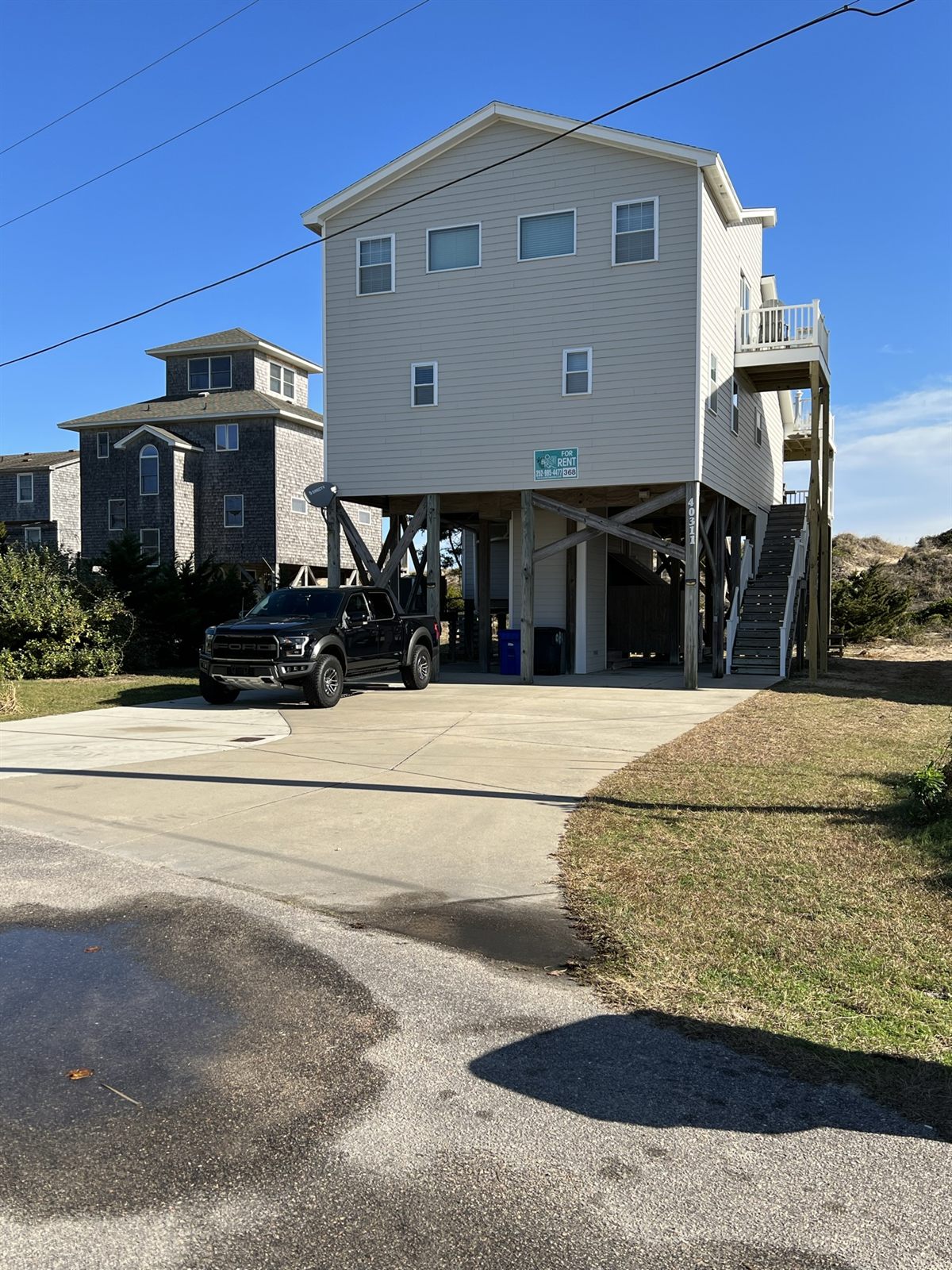 The beach house from the driveway under blue sky