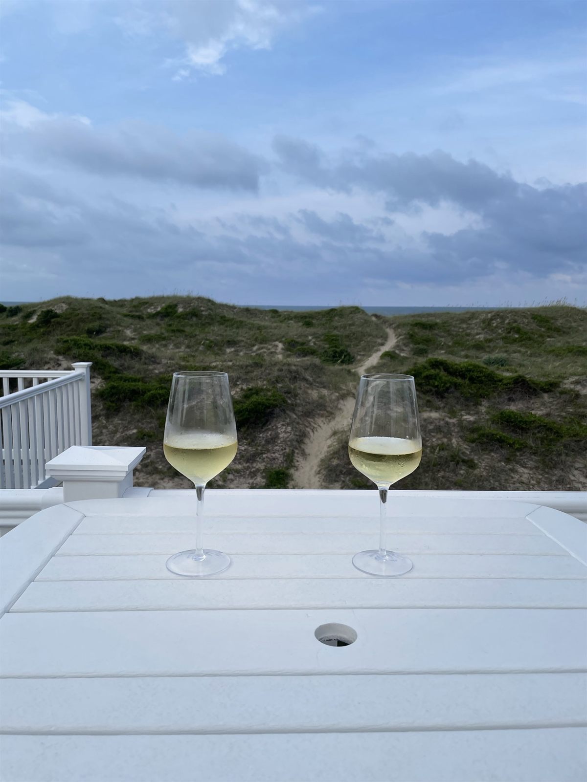Glasses of wine on the deck overlooking the dunes and ocean