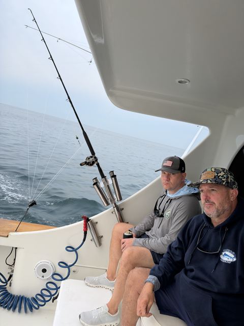 Two anglers on the gunwale watching the lines