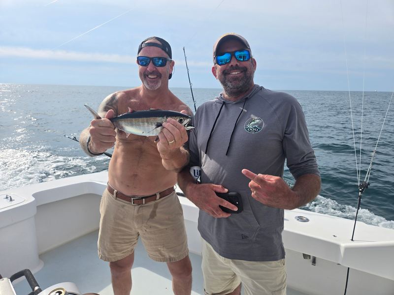 Two of the Drifter crew holding up a blackfin tuna